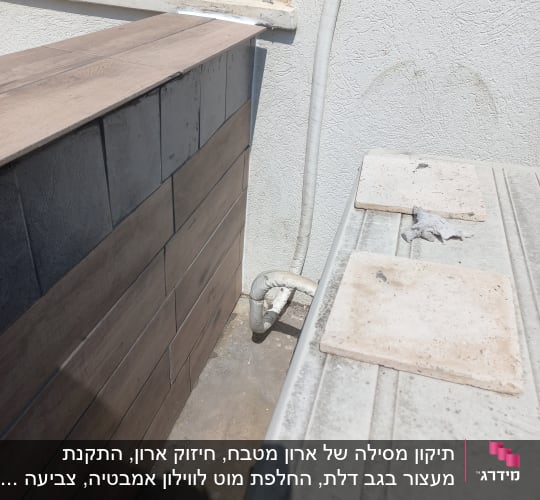 אריחים וצינור ליד קיר חיצוני